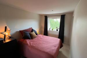 Bærums VerkNyoppusset 2 roms leilighet til leie på Rykkinn的卧室配有粉红色的床和窗户