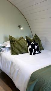 BallymaganThe Garden Pod with Private Hot Tub的一张带绿色和白色枕头的床