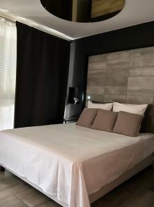 圣西普里安Superbe appartement avec balnéo.的一间卧室配有一张大床,配有白色床单和棕色枕头