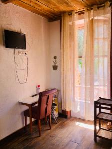 圣罗兰度瓦Laurentissime的一间房间,墙上设有一张桌子和一台电视机