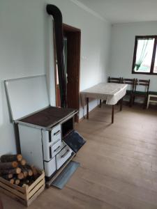 维尔蒂尼克Kuca idealna za odmor i uzivanje u Vrdniku broj 4的一间带炉灶、桌子和长凳的房间
