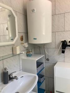 帕格Apartmani Fijan的一间带水槽和白色橱柜的浴室