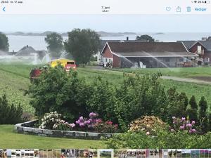 拉尔维克Ny Leilighet i Nevlunghavn的田野里开的火车,有房子和鲜花