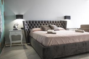 兰佩杜萨Incanto Luxury Rooms的一间卧室配有一张带软垫床头板的床和一张桌子