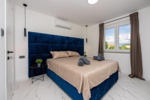 巴斯卡Vila Kety的一间卧室配有一张大床和蓝色床头板