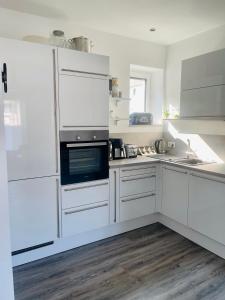 弗里茨拉尔Apartment Lindenstein的厨房配有白色橱柜和炉灶烤箱。