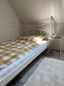 不来梅港Ferienwohnung in Bremerhaven的一间卧室配有一张床和一张边桌