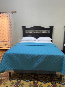 危地马拉Hotel Malybu的一张蓝色的床,上面有两个枕头