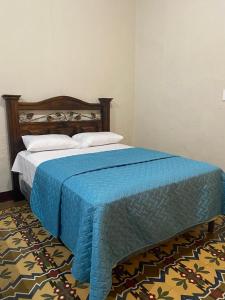 危地马拉Hotel Malybu的一间卧室配有一张带蓝色毯子的床