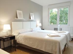 科尔多瓦Conde de Vallellano的白色卧室设有一张大床和两个窗户