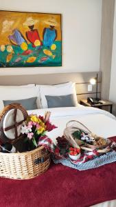 新汉堡市诺华汉伯格商务酒店的床上有一篮子食物和鲜花