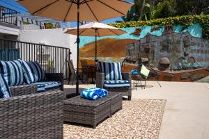 拉古纳海滩Art Hotel Laguna Beach的庭院配有两把椅子和一把遮阳伞