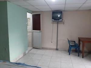 弗朗西斯科德奥雷利亚纳港Residencial RM的一间房间,墙上有椅子和电视