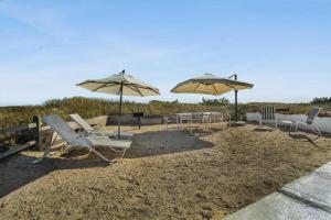 蒙托克漂流木海上度假酒店的海滩上的一组椅子和遮阳伞