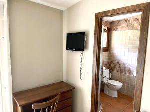 ArmallonesCasa Rural Valito的一间带卫生间的浴室和墙上的电视