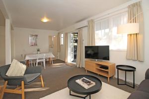 奥克兰2 Bed Apartment in Kingsland - FREE WIFI and parking的一间带电视和桌子的客厅
