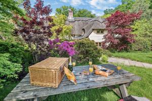 BreamoreThe Cottage, Beautiful New Forest 5 Bedroom Thatched Cottage的野餐桌上放着一篮子和蔬菜