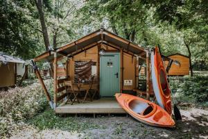 希欧福克Sioglamping in Siocamping的旁边一个小棚屋,旁边放着皮艇