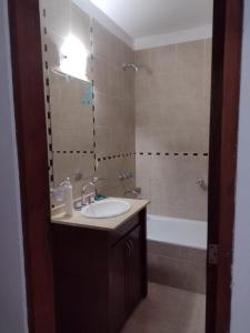 里奥夸尔托Departamentos modernos en Rio Cuarto Yrigoyen的一间带水槽、浴缸和镜子的浴室