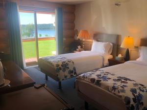 Lac La HacheCariboo Log Guest House的酒店客房设有两张床和大窗户。