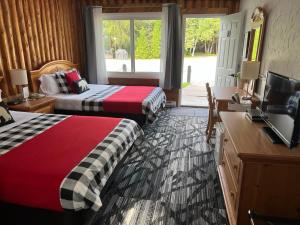 沃瓦神秘岛汽车旅馆 的酒店客房设有两张床、一张桌子和一台电视。