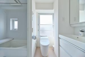 东京TORA HOTEL Sensoji 寅ホテル 浅草寺的白色的浴室设有卫生间和窗户。
