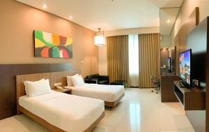 玛琅Savana Hotel & Convention Malang的酒店客房设有两张床和一台平面电视。