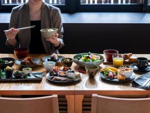 京都三井花园饭店 京都新町别邸的坐在餐桌上吃盘子的女人