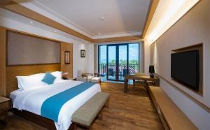 三亚海旅·君澜三亚湾迎宾馆的一间卧室配有一张大床和一台平面电视