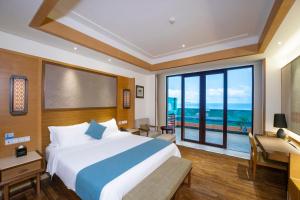 三亚海旅·君澜三亚湾迎宾馆的一间卧室设有一张大床和一个大窗户