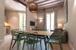 巴塞罗那圣安东尼市场威孚勒汀公寓的一间带木桌和绿色椅子的用餐室