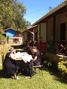 维奥康德马奥Chalés das Orquídeas的坐在院子里桌子上的一群妇女