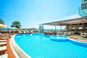 波塞蒂Xenios Possidi Paradise Hotel的一个带椅子的大型游泳池,一个度假村