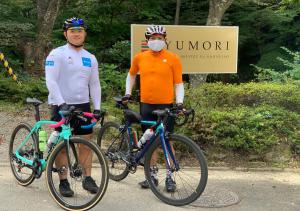 福岛YUMORI ONSEN HOSTEL的两个戴面具的男人站在自行车旁边