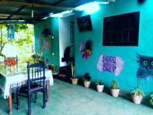 埃拉Cozy House Hostel的一间设有桌子的房间和种植了植物的蓝色墙壁