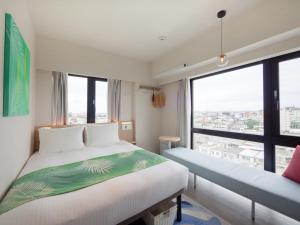 宫古岛Tabino Hotel lit Miyakojima的酒店客房设有两张床和大窗户。