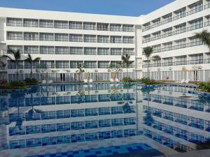 龙目岛库塔Raja Hotel Kuta Mandalika Resort & Convention的享有酒店外景和游泳池景色
