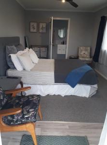 汉密尔顿Rural Gordonton Sleepout的一间卧室配有一张大床和一张沙发