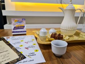 布赖代Shams Alshate شمس الشاطئ的餐桌,餐桌上放着一盘食物和一杯牛奶