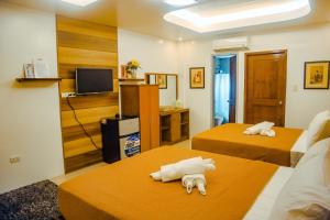 圣安东尼奥Youhan Beach Resort的一间酒店客房,设有两张床和电视