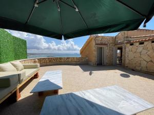 El DjamilaVilla vue sur mer的一个带沙发和遮阳伞的庭院