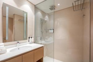 迪拜Holiday Inn & Suites - Dubai Science Park, an IHG Hotel的一间带水槽和淋浴的浴室