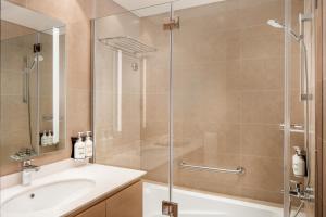 迪拜Holiday Inn & Suites - Dubai Science Park, an IHG Hotel的带淋浴和盥洗盆的浴室
