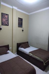 新加拉惹DK Hotel Singaraja的小型客房配有两张床,设有2张床。