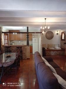 莱图尔Casa Rural Juan, el Zapa的带沙发和桌子的客厅以及厨房。