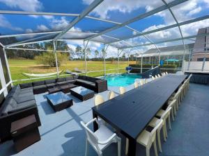 达文波特14 Room DisneyEstate by AmericanVacationliving的一个带桌椅的庭院和一个游泳池