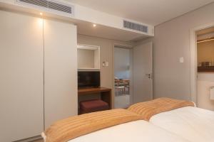 巴利托Indigo 2 Bed Zimbali Suites Sea View的一间卧室配有一张床和一台电视
