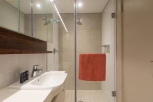 巴利托Indigo 2 Bed Zimbali Suites Sea View的一间带水槽和玻璃淋浴的浴室