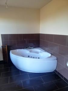SławoborzePeace & Quiet的浴室铺有棕色瓷砖,配有白色浴缸。