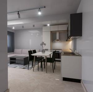 都拉斯Split Rooftop Suites的厨房以及带桌椅的起居室。
